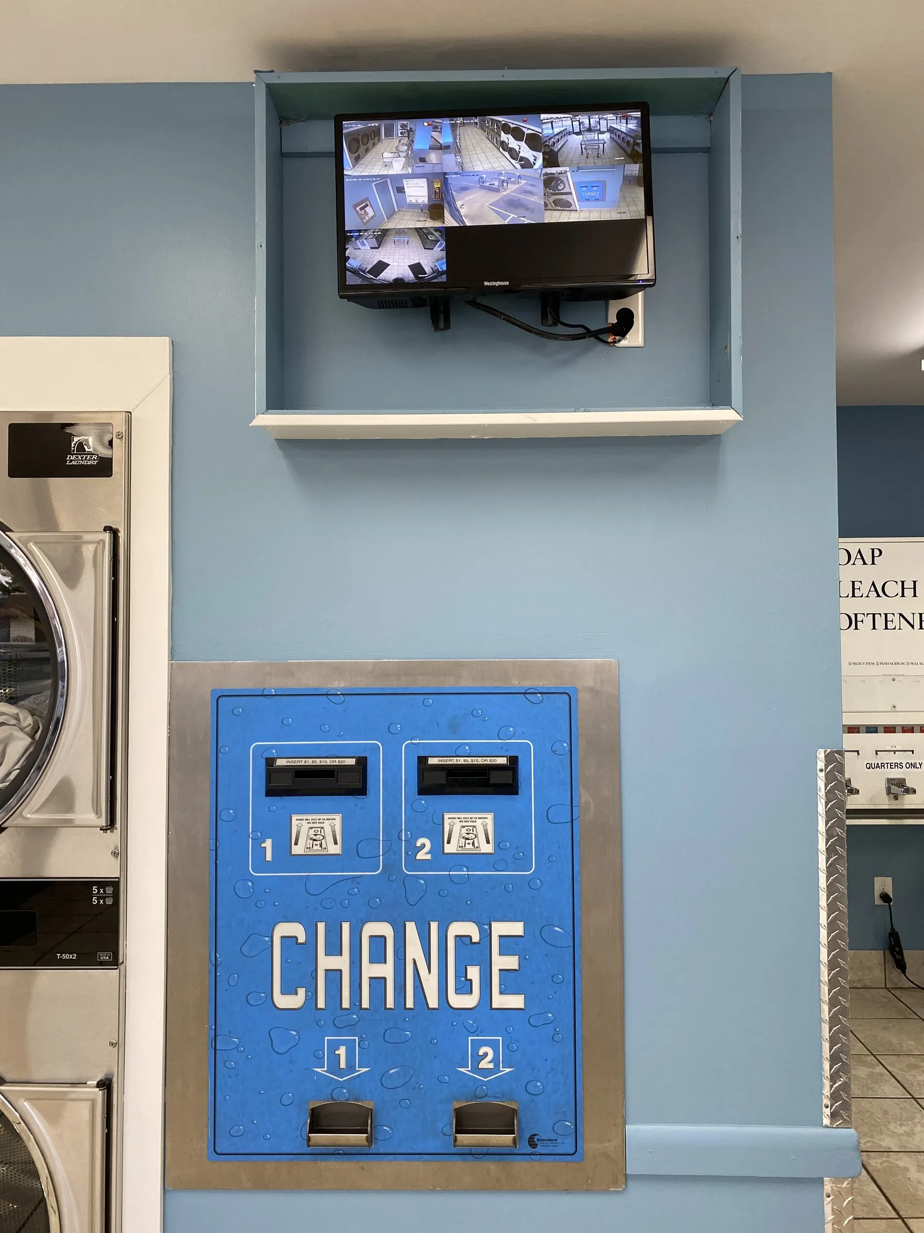 A wall-mounted security monitor showing live views from six cameras around the store.