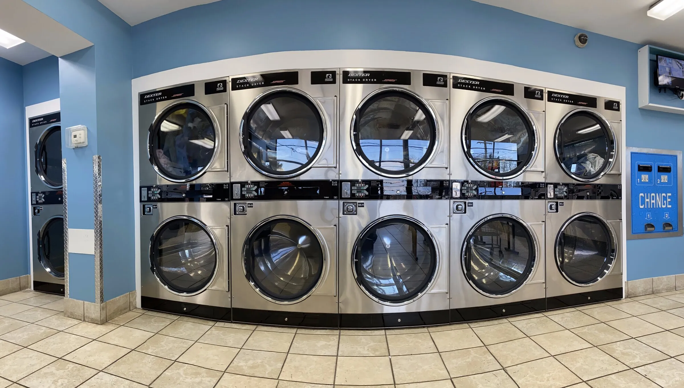 A bank of stacked dryers, two doors high, along one wall.