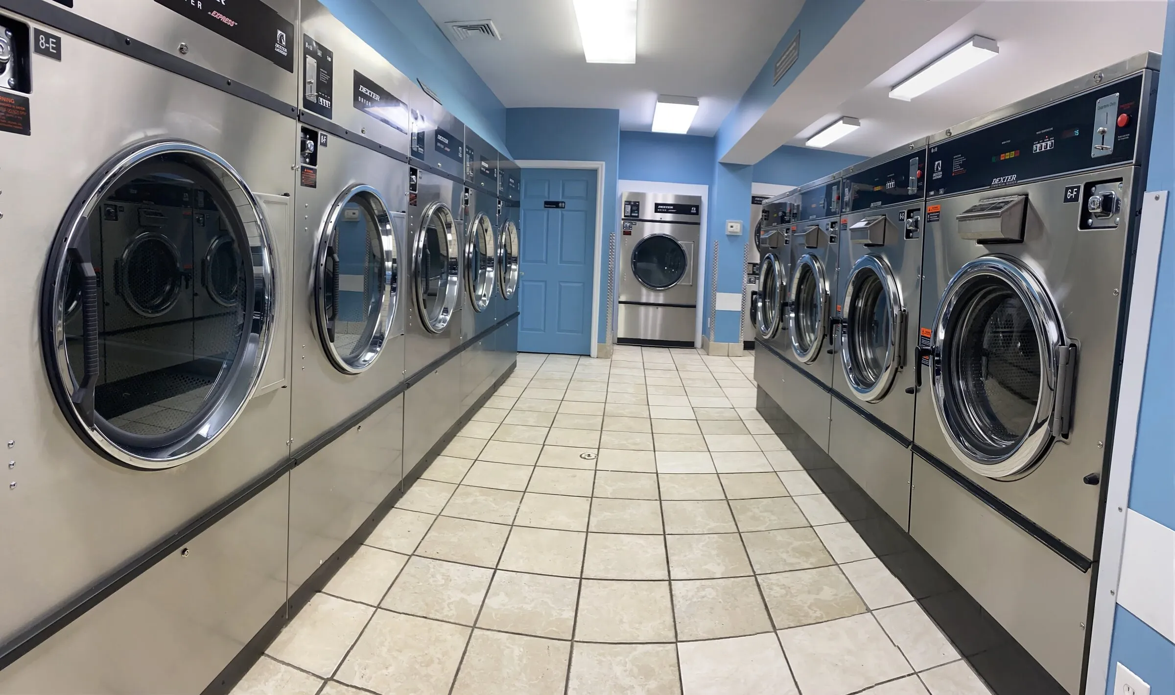 A clean aisle between two facing rows of front-load washers.