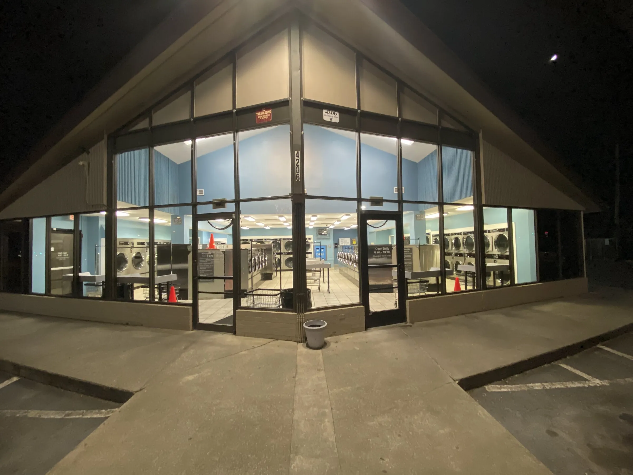 The store's glazed corner front at night, lit from inside.